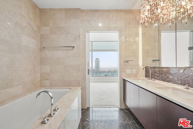 bathroom featuring a washtub, tile walls, vanity, and an inviting chandelier