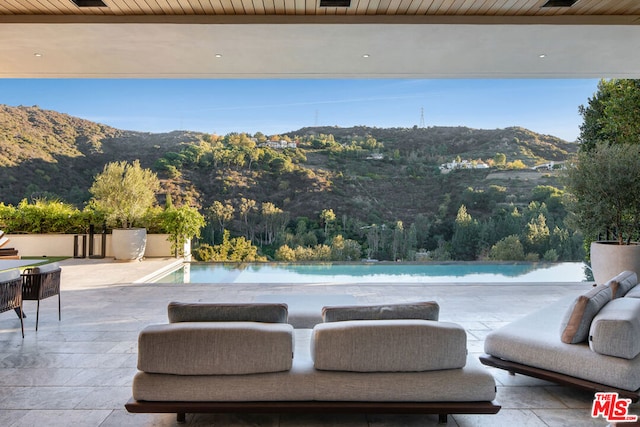 view of swimming pool with a mountain view and a patio