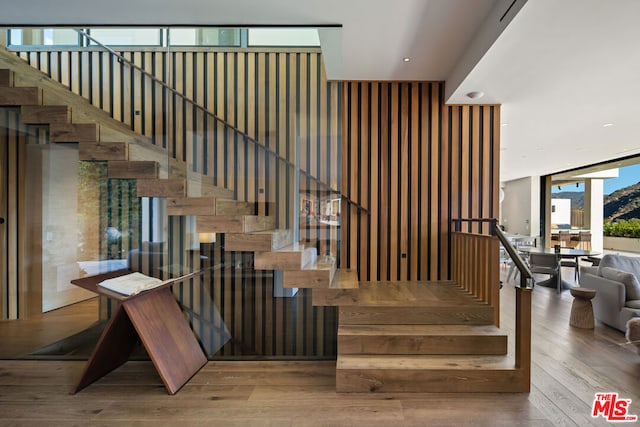 stairs featuring wood-type flooring and expansive windows