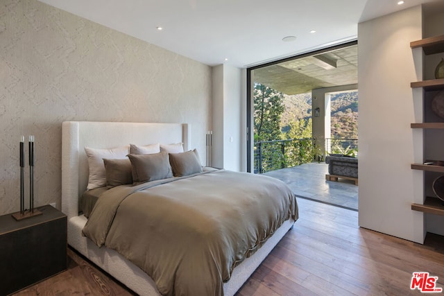 bedroom featuring hardwood / wood-style flooring and expansive windows