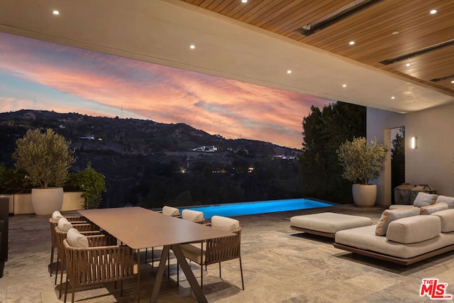 patio terrace at dusk featuring a mountain view