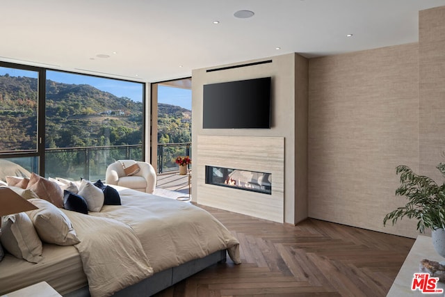 bedroom featuring dark parquet floors and a wall of windows