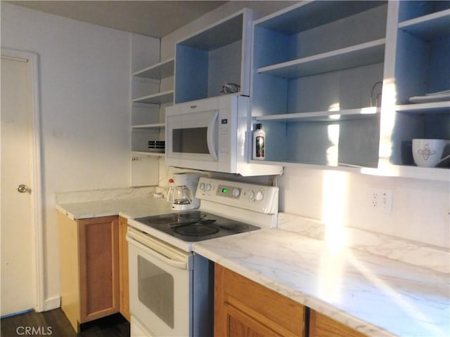 kitchen featuring light stone counters, white appliances, and dark hardwood / wood-style flooring