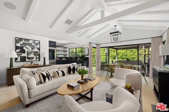 living room featuring lofted ceiling with beams and light hardwood / wood-style floors