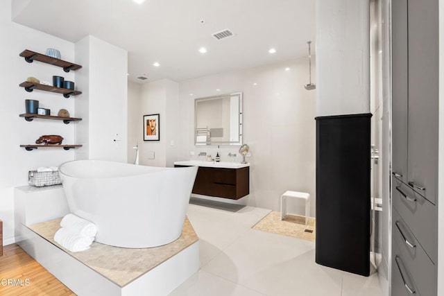 bathroom with plus walk in shower, hardwood / wood-style floors, and vanity