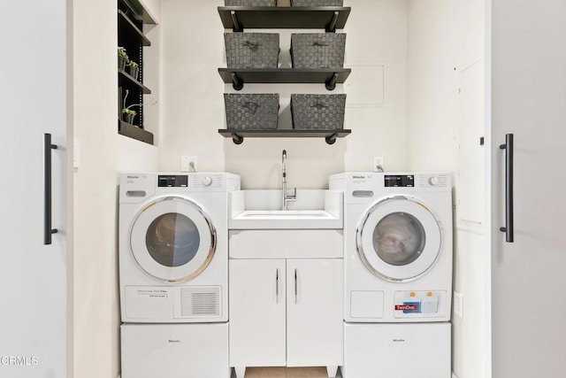 washroom with washing machine and dryer, sink, and cabinets