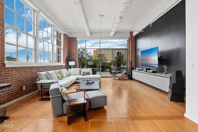 living room featuring light hardwood / wood-style floors and brick wall