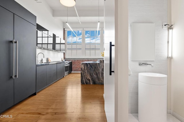 bathroom with sink, wood-type flooring, and tile walls