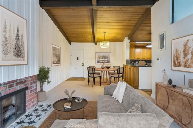 living room with lofted ceiling with beams, a brick fireplace, wooden ceiling, and a notable chandelier