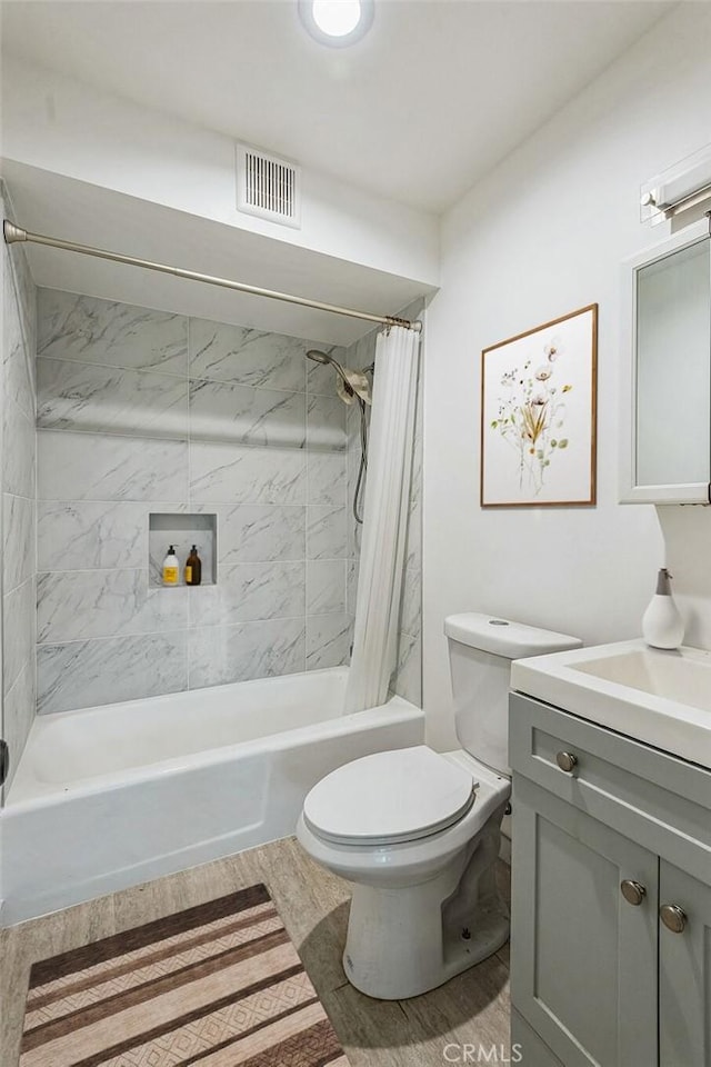 full bathroom featuring hardwood / wood-style floors, vanity, shower / tub combo, and toilet