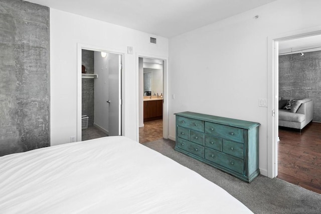 carpeted bedroom featuring ensuite bath and a closet