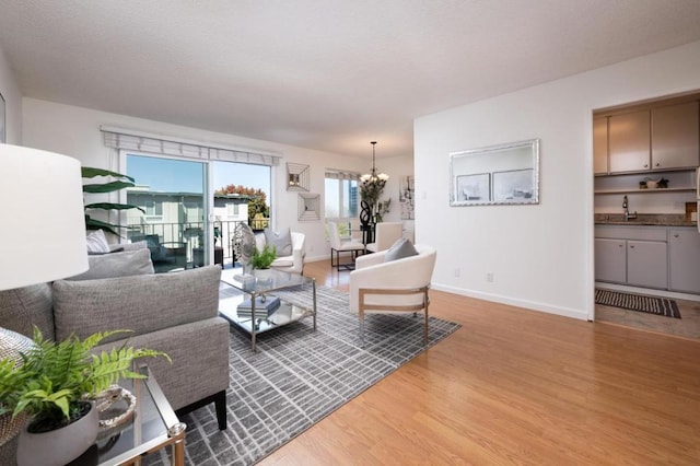 living room featuring a notable chandelier and light hardwood / wood-style flooring