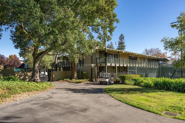 view of front of home featuring a front yard and a balcony