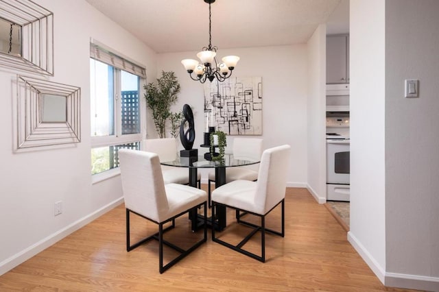 dining area featuring light hardwood / wood-style floors and a chandelier