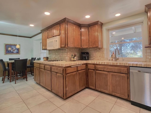 kitchen with sink, tile counters, tasteful backsplash, appliances with stainless steel finishes, and ornamental molding