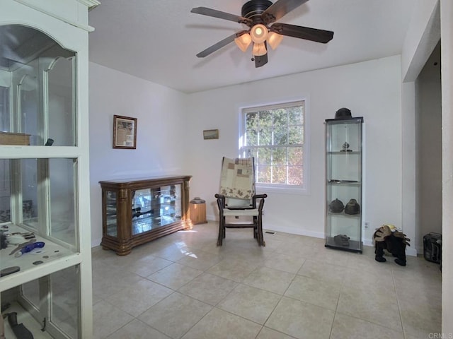 living area featuring light tile patterned floors and ceiling fan