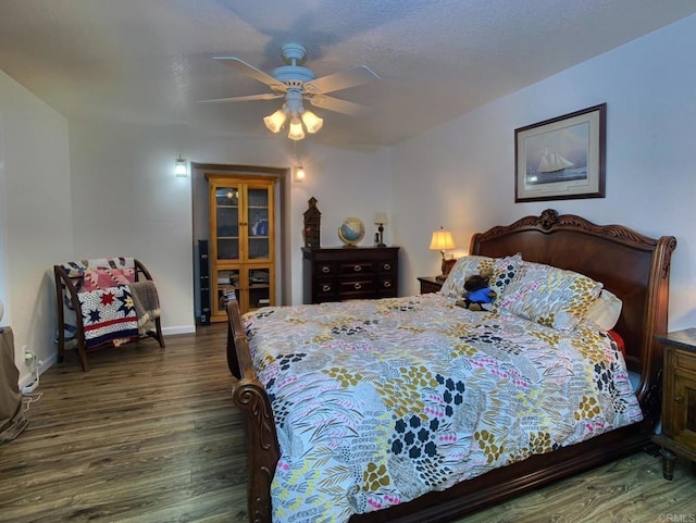 bedroom with dark hardwood / wood-style flooring and ceiling fan