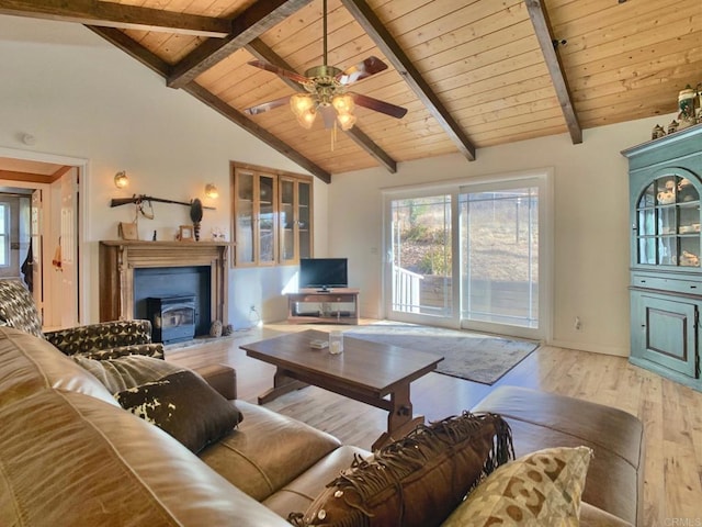 living room with beam ceiling, high vaulted ceiling, light hardwood / wood-style flooring, wooden ceiling, and a wood stove