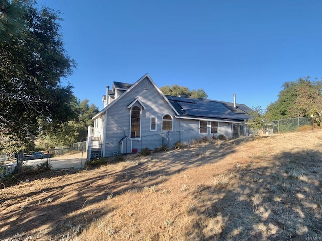 rear view of house featuring solar panels