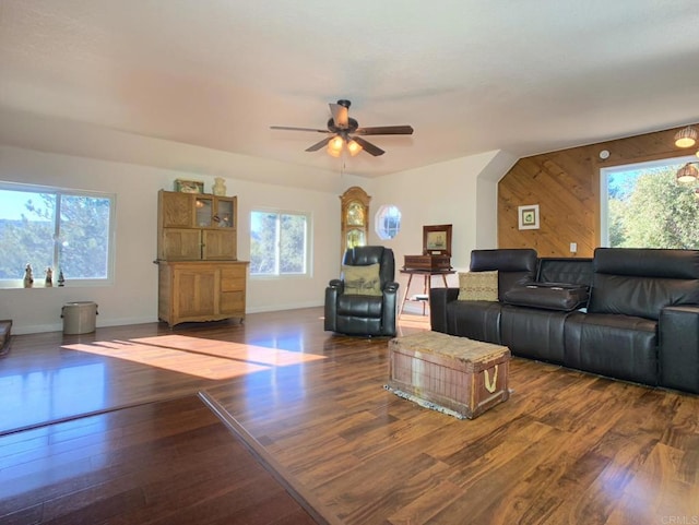 living room with a wealth of natural light, wood walls, and dark hardwood / wood-style floors