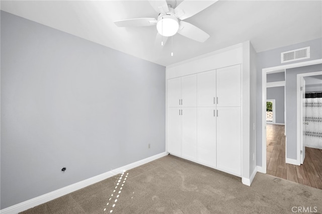 unfurnished bedroom with hardwood / wood-style flooring, ceiling fan, and a closet