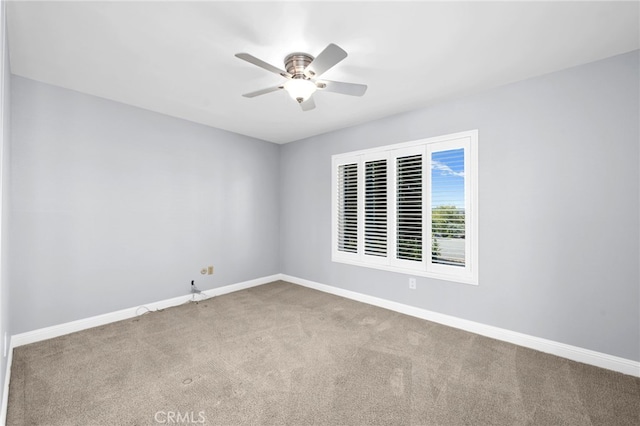 carpeted spare room featuring ceiling fan