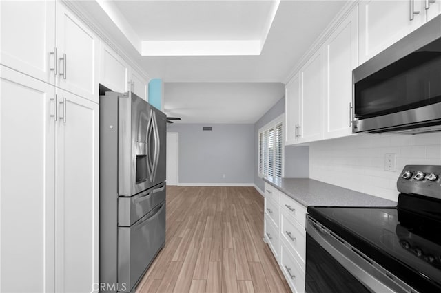 kitchen with white cabinetry, ceiling fan, backsplash, appliances with stainless steel finishes, and light wood-type flooring