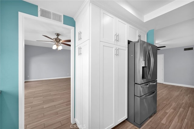 kitchen with ceiling fan, light wood-type flooring, white cabinetry, and stainless steel refrigerator with ice dispenser