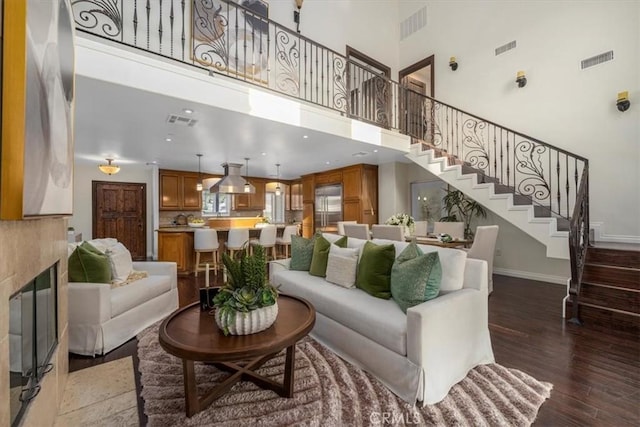 living room featuring a towering ceiling and dark hardwood / wood-style floors