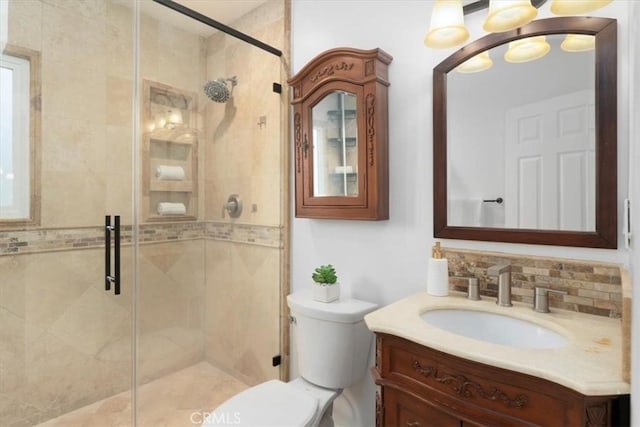 bathroom featuring vanity, toilet, an enclosed shower, and tasteful backsplash