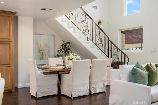 dining room featuring a high ceiling and dark hardwood / wood-style floors