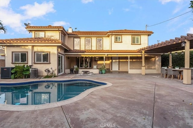 back of property with a pergola, a patio area, and central AC unit