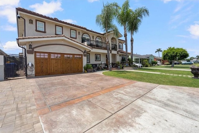 mediterranean / spanish-style home with a garage, a balcony, and a front yard