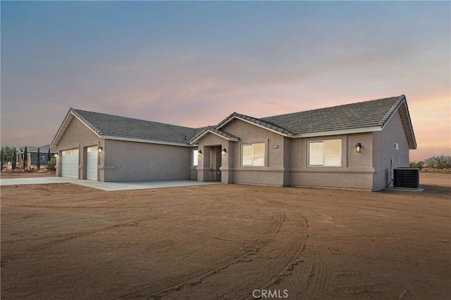 ranch-style home with cooling unit and a garage