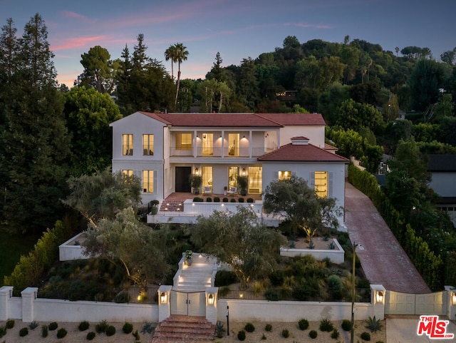 back house at dusk with a balcony