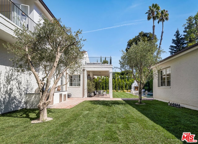 view of yard featuring a balcony and a patio