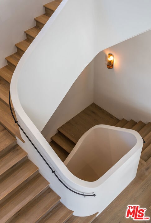 staircase with hardwood / wood-style flooring