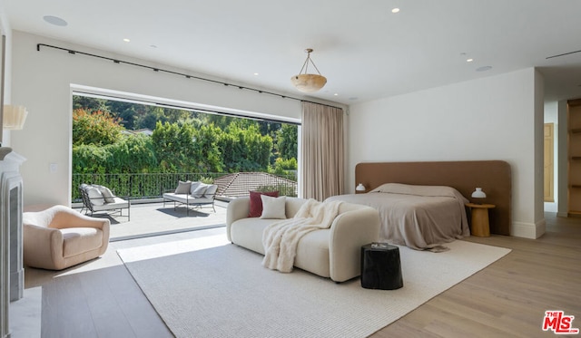 bedroom with light hardwood / wood-style floors and access to exterior