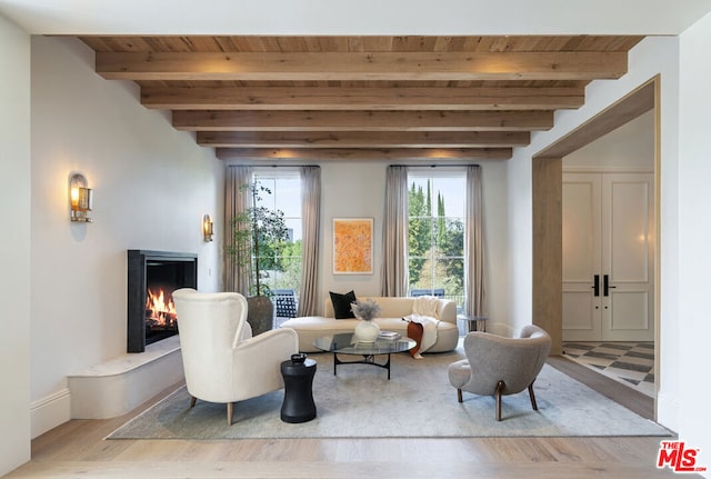 living area featuring beam ceiling, wooden ceiling, and light wood-type flooring