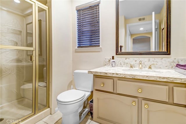 bathroom with tile patterned flooring, a shower with door, vanity, and toilet