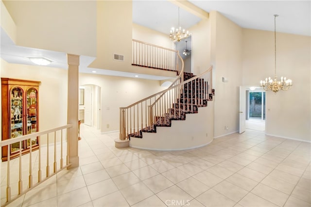 staircase featuring tile patterned flooring, an inviting chandelier, and high vaulted ceiling