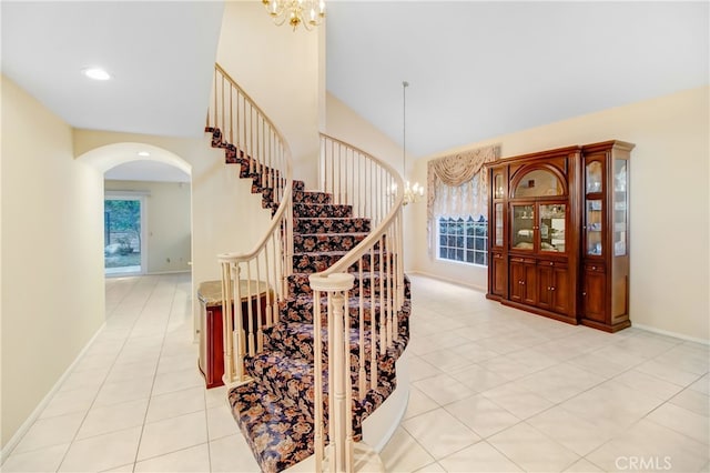 stairs featuring tile patterned flooring and a chandelier