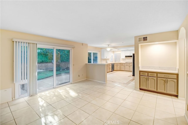 unfurnished living room featuring light tile patterned floors and ceiling fan