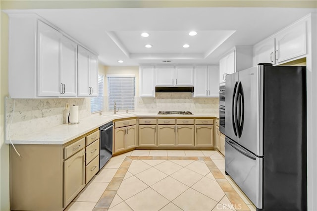 kitchen featuring sink, light tile patterned floors, a tray ceiling, tasteful backsplash, and stainless steel appliances