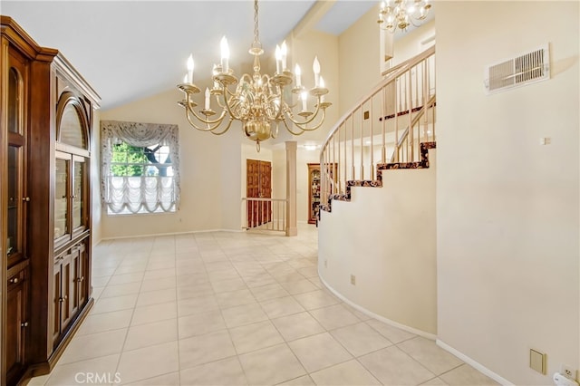 tiled entryway featuring a chandelier and high vaulted ceiling