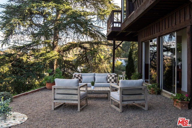 view of patio with an outdoor living space and a balcony