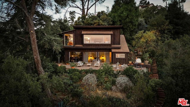 back of house with an outdoor living space and a patio area