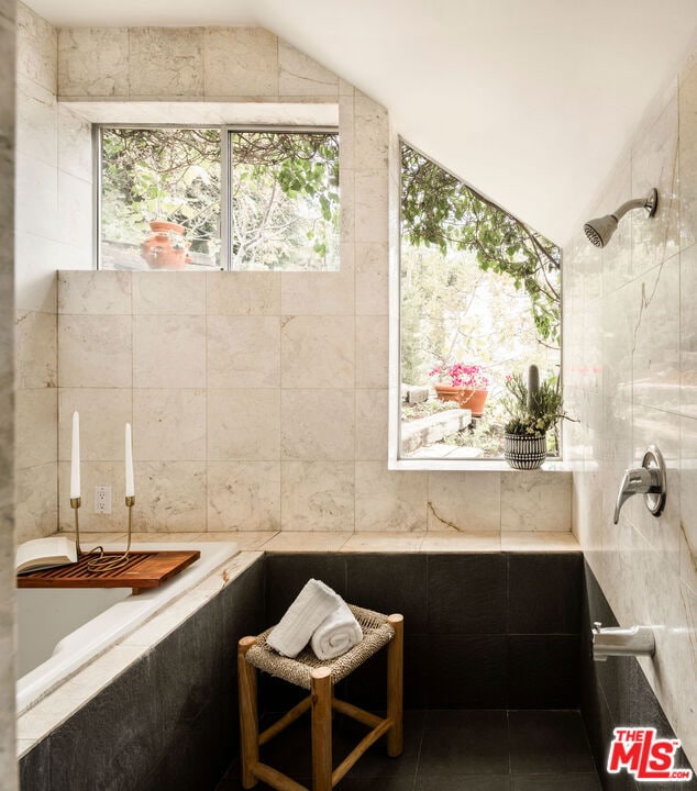 bathroom with tile walls, tile patterned flooring, and vaulted ceiling