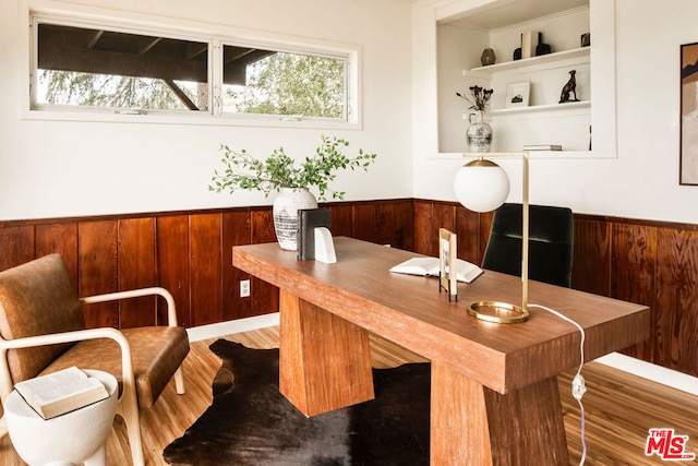 home office with wooden walls and hardwood / wood-style floors