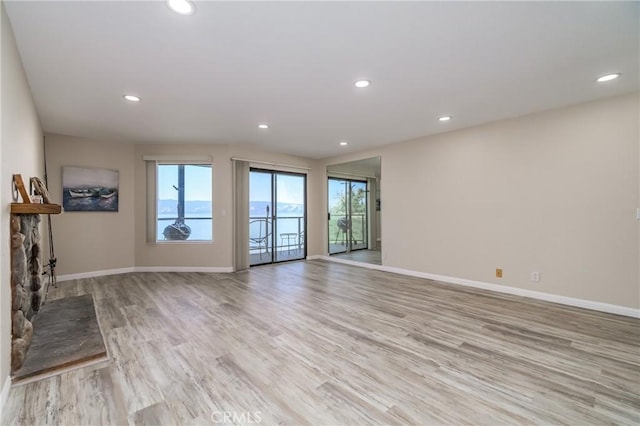 unfurnished living room featuring a fireplace and light hardwood / wood-style floors